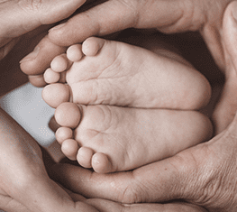 two hands holding baby feet