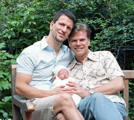 Two men holding a baby